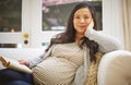 Ive got to take it easy before the baby arrives. Portrait of a pregnant woman reading a book at home.