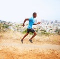 Ive gotta beat my time. A young man running along a nature trail with the city in the background. Royalty Free Stock Photo