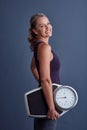 Ive reached my goal weight. Studio portrait of an attractive mature woman holding a weightscale against a blue Royalty Free Stock Photo