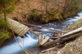 Iver Pylypets with fast current, a broken wooden bridge in the forest, fallen leaves and driftwood on banks of the creek Royalty Free Stock Photo