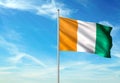 Cote d`Ivoire Ivory coast flag waving with sky on background realistic 3d illustration