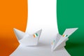 Ivory Coast flag depicted on paper origami airplane and boat. Handmade arts concept