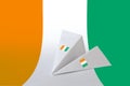 Ivory Coast flag depicted on paper origami airplane. Handmade arts concept