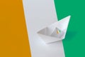 Ivory Coast flag depicted on paper origami ship closeup. Handmade arts concept