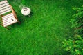 Ivory colored grill on the grass near the wooden armchair with a book and glasses. Top view