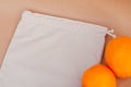 Ivory pouch for fruits and vegetables on paper background with orange oranges. concept of zero waste, the protection of ecology