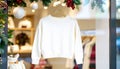 Ivory Sweater Displayed on Hanger with Christmas Decorations in Storefront Window Royalty Free Stock Photo
