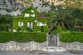 Ivy house and green garden with Palm in europe against mountain Royalty Free Stock Photo