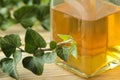 Ivy leaf and syrup in a bottle on a natural wooden table. Production of cough medicine with ivy extract. pharmaceutical industry Royalty Free Stock Photo
