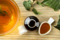 Ivy leaf and syrup in a bottle on a natural wooden table. Production of cough medicine with ivy extract. pharmaceutical industry Royalty Free Stock Photo