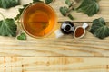 Ivy leaf and syrup in a bottle on a natural wooden table. Production of cough medicine with ivy extract. pharmaceutical industry Royalty Free Stock Photo