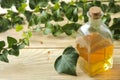 Ivy leaf and syrup in a bottle on a natural wooden table. Production of cough medicine with ivy extract. pharmaceutical industry Royalty Free Stock Photo