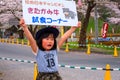 Unidentified young Japanese girl holds sign selling the Kitakami beef