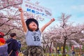 Unidentified young Japanese girl holds sign selling the Kitakami beef