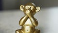 Of Iwazaru monkey statue who speaks no evil and a gesticulating man in the background