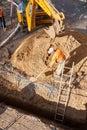 Izhevsk, Russia - May 08 2021: Skilled workers bury deep trench during lying new pipeline