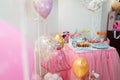 Candy bar with muffins, donuts and cake pops for girl birthday. Party balloons with Frozen cartoon character and number five Royalty Free Stock Photo
