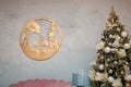 Wooden carved picture with trees and two deer hanging on the wall. Christmas fir-tree and new year