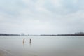 Two girls in water. Christening or baptism bathing in winter river. January rite, religious tradition or ritual of God believers