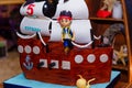 Boy birthday cake in shape of sea ship with captain mastic figure. Inscription reads Kirill is 5 years old Royalty Free Stock Photo