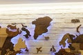 Wooden decorative world map with purple neon backlight on apartment wall. Modern interior design.