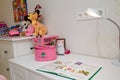 Izmail, Ukraine. March 2021. Working place for pre-schooler girl, desk, table lamp, book for reading learning, pencils, bright