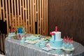 Festive candy bar for 1 and 5 years old boys birthday party. Cake with red number 1 and butterfly bow on shirt. Blue cakepops