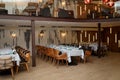Modern restaurant interior with rows of tables and chairs and festive settings for event r party Royalty Free Stock Photo