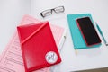 Izmail, Ukraine, May 2021. Two red and turquoise notebooks on white table with pens, glasses. Business details. Dairy planner for