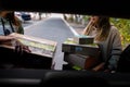 Izmail, Ukraine, May 2021. Two women taking carton packages, parcels out of car