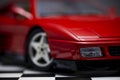 Red toy Ferrari 348TB sports car close up product shot on a chequered ground and gray background Royalty Free Stock Photo