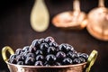 Jaboticaba or jabuticaba, Brazilian and South American fruit, in a copper pot on a rustic table. Fruit for medicinal and culinary