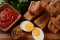 Jachnun or Jahnun, Yemenite Jewish pastry, served with fresh grated tomato and boiled egg and Zhug,