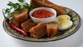 Jachnun or Jahnun, Yemenite Jewish pastry, served with fresh grated tomato and boiled egg and Zhug,