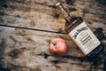 Jack Daniels Honey liqueur and apple fruit at weathered wooden background