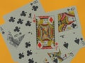 The Jack of Diamonds playing card is placed above other playing cards of different suits on a yellow background.