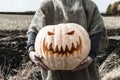 Jack-lantern with his head in his hands in the field. Royalty Free Stock Photo