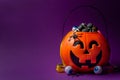 Jack-o-lantern bag full of candy on a purple background with copy space, horizontal Royalty Free Stock Photo