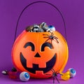 Jack-o-lantern bag full of candy on a purple background, square Royalty Free Stock Photo