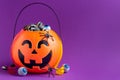 Jack-o-lantern bag full of liquorice candy on purple background with copy space,  horizontal Royalty Free Stock Photo