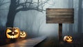 Halloween concept with Jack o Lanterns and wooden road sign in the spooky forest Royalty Free Stock Photo