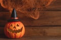 Jack-o-latern against the background of cobweb with two spiders. Halloween postcard. Selective focus, copy space for