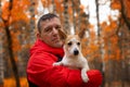 A Jack Russell terrier in the arms of a man. A small dog in the park in nature. Pets Royalty Free Stock Photo