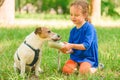 On hot summer day girl watering dog in park. Dog drinking water from special pet bottle