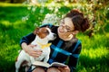 Jack Russell Terrier dog with owner woman playing in the spring outdoors. Modern Youth Lifestyle Concept.