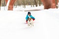 Smiling kid musher and his sled dog having fun at winter park Royalty Free Stock Photo