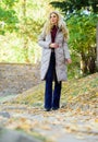 Jacket everyone should have. Puffer fashion trend concept. Girl fashionable blonde walk in autumn park. Oversized jacket