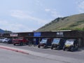 Street view with cars and ATVs parked outside wooden shops in Jackson Hole