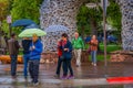 JACKSON, WYOMING, USA, JUNE, 07, 2018: Unidentified people holding umbrellas in front of elk antler arches curve over