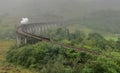 The Jacobite steam train crossing over the Glenfinnan viaduct in the rain